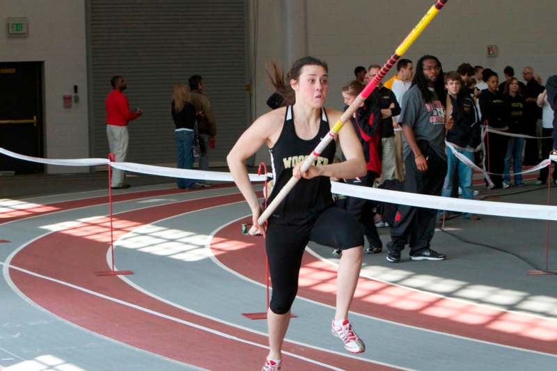 a woman holding a pole in a track