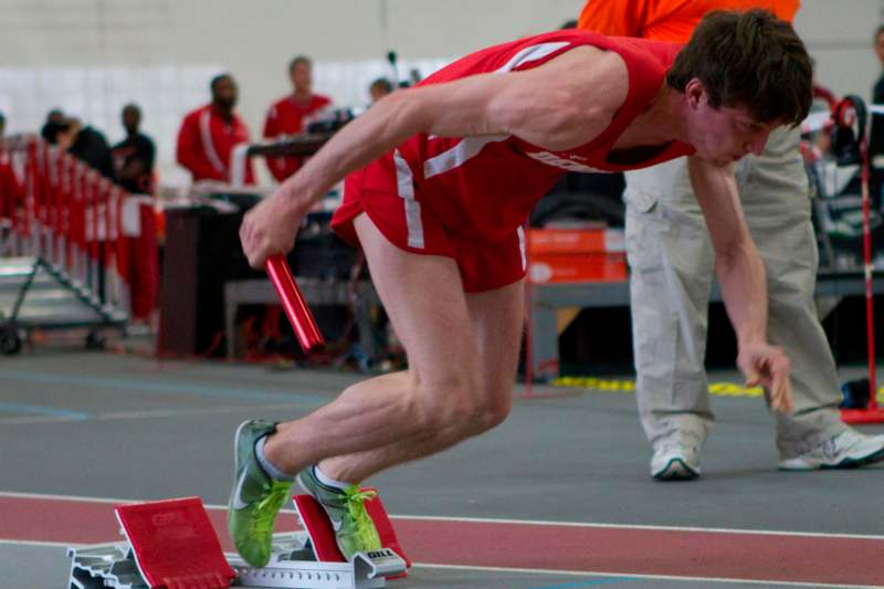 a man in a red uniform running on a track