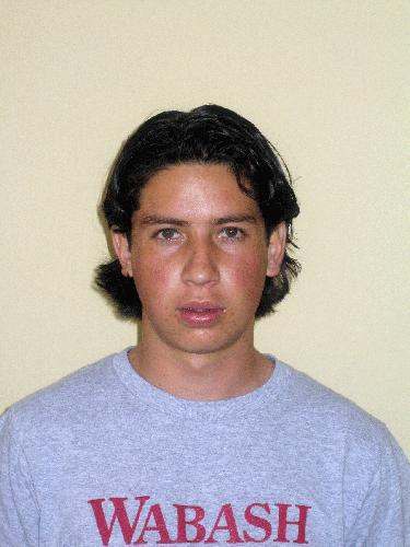 a man with dark hair wearing a blue shirt