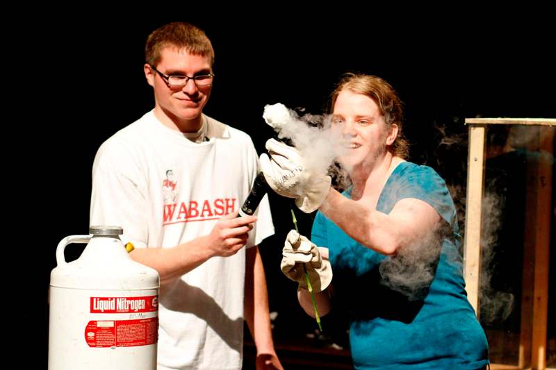 a man and woman holding a stick with smoke coming out of them