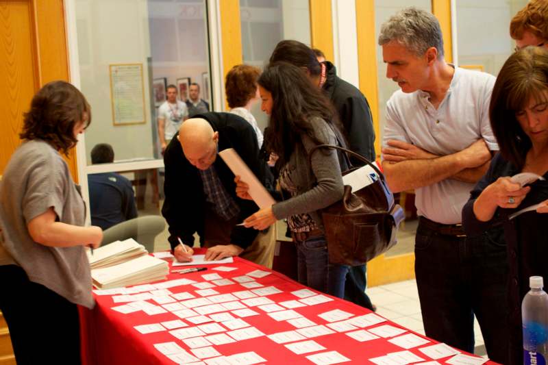 a group of people standing around a table with papers on it