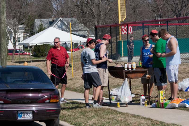 a group of people standing around a barbecue
