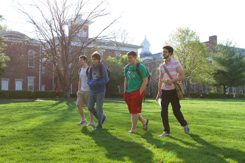 a group of men walking on a grass field