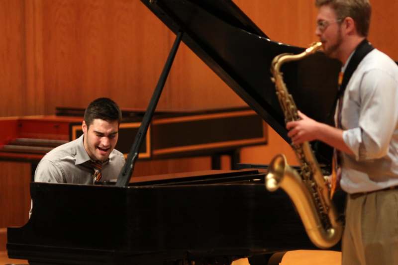 a man playing a saxophone next to a man playing a piano