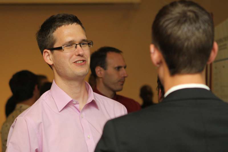 a man in a pink shirt talking to another man