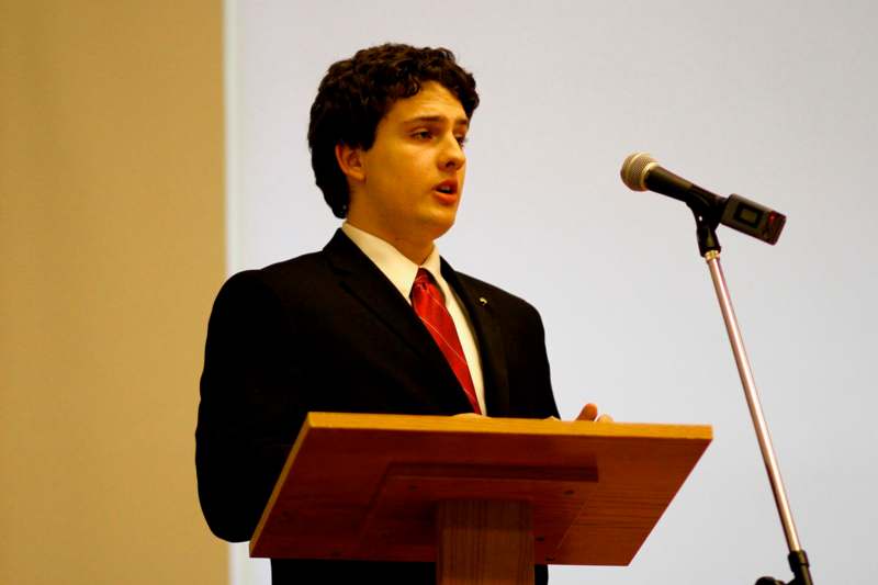 a man standing at a podium with a microphone