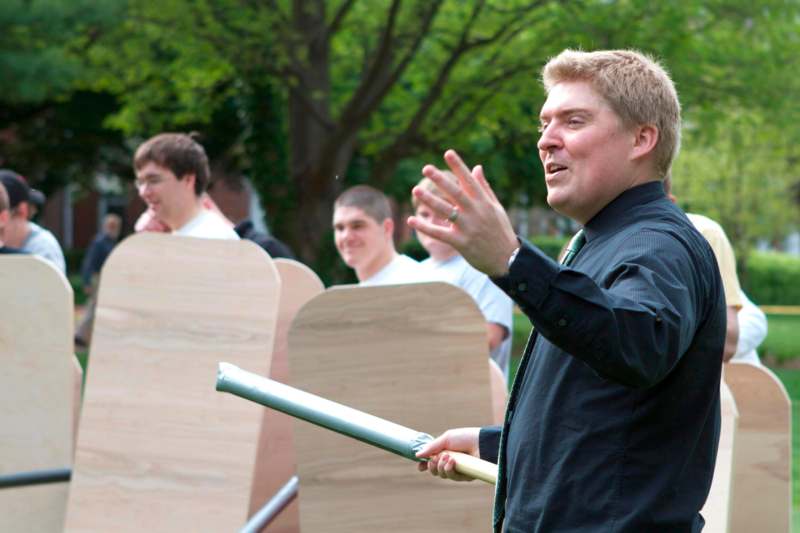 a man holding a baton in front of a group of people