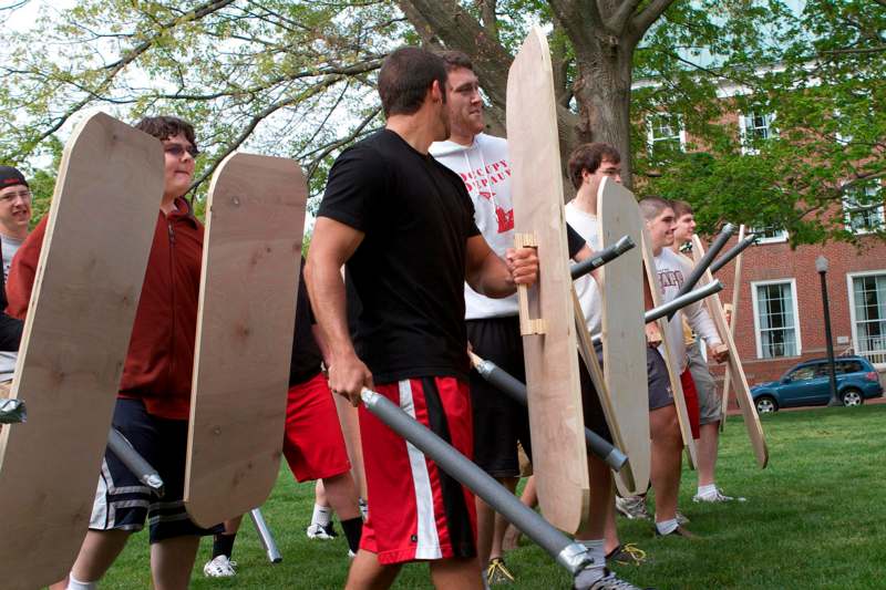 a group of people holding wooden shields