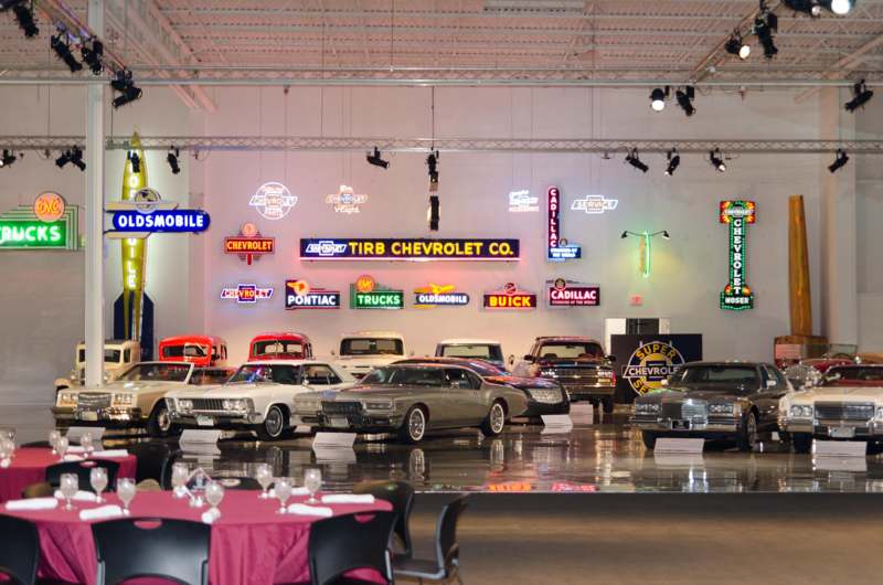 a room with many cars and neon signs