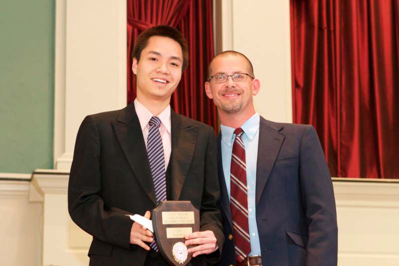 a man holding a plaque with a man standing next to him