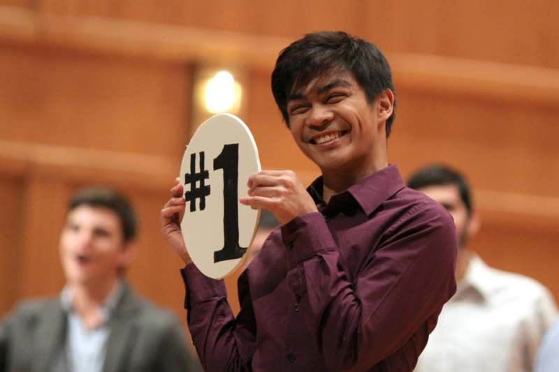 a man holding a sign with number one