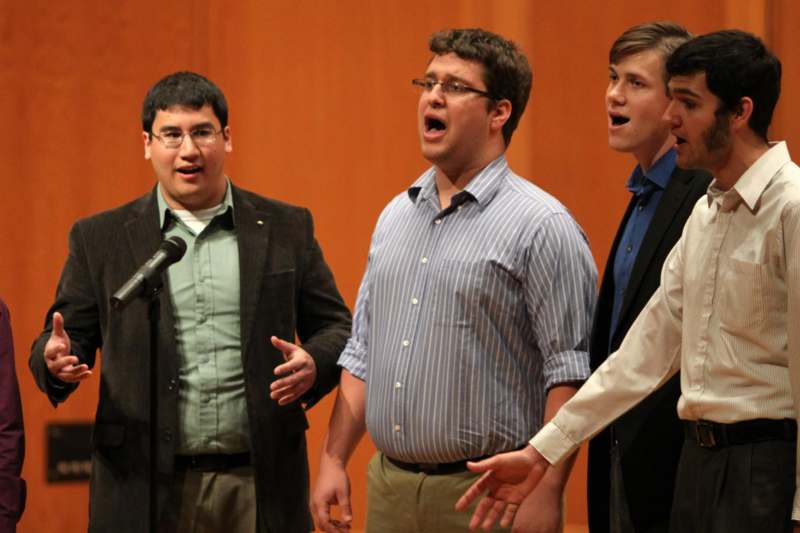 a group of men singing into a microphone