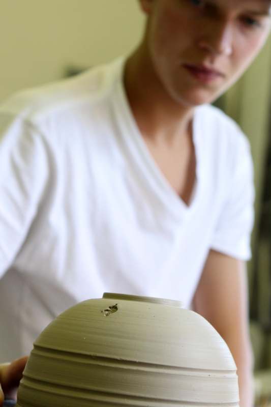 a person looking at a small insect on a bowl