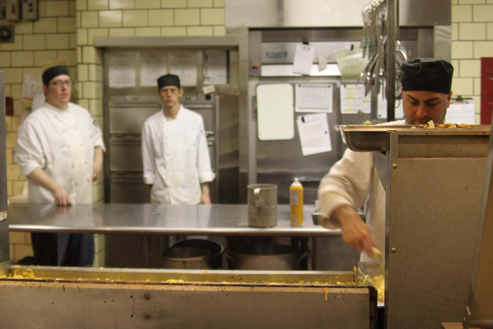 a group of chefs cooking in a kitchen