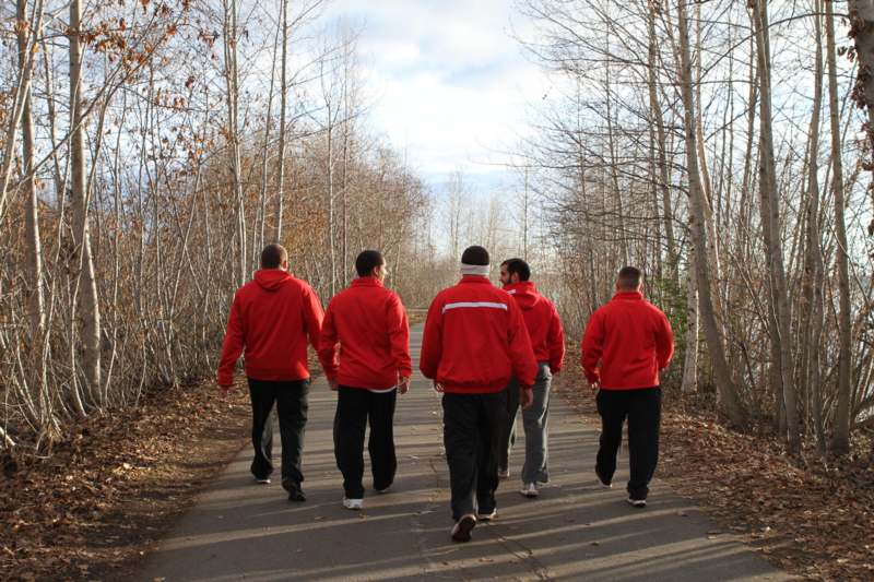 a group of men walking on a path with trees