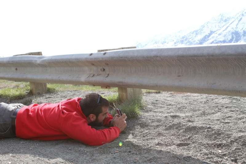 a man lying on the ground looking at his phone