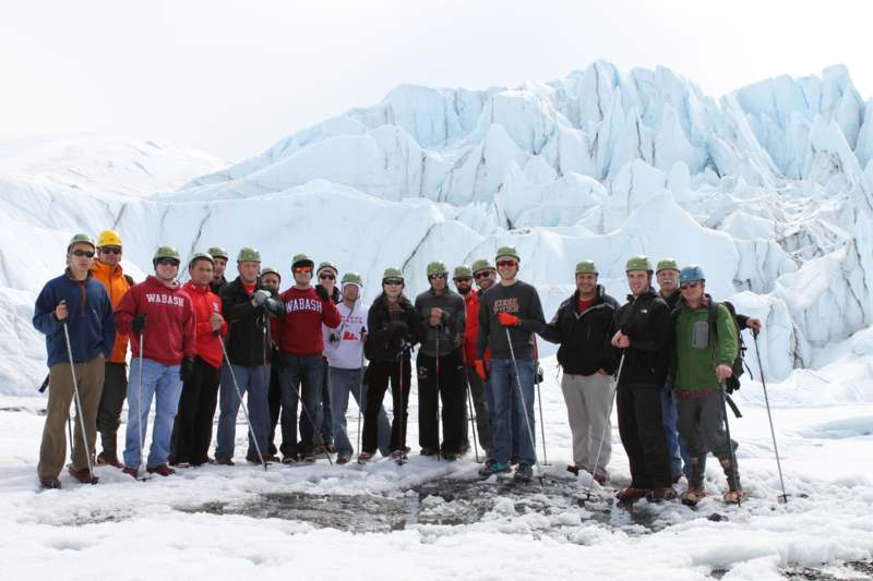 a group of people posing for a photo in front of a snowy mountain