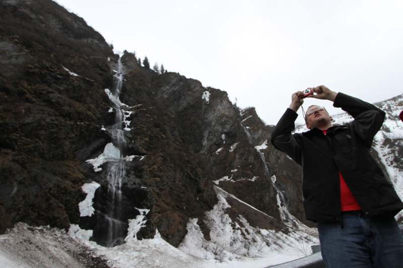 a man taking a picture of a waterfall