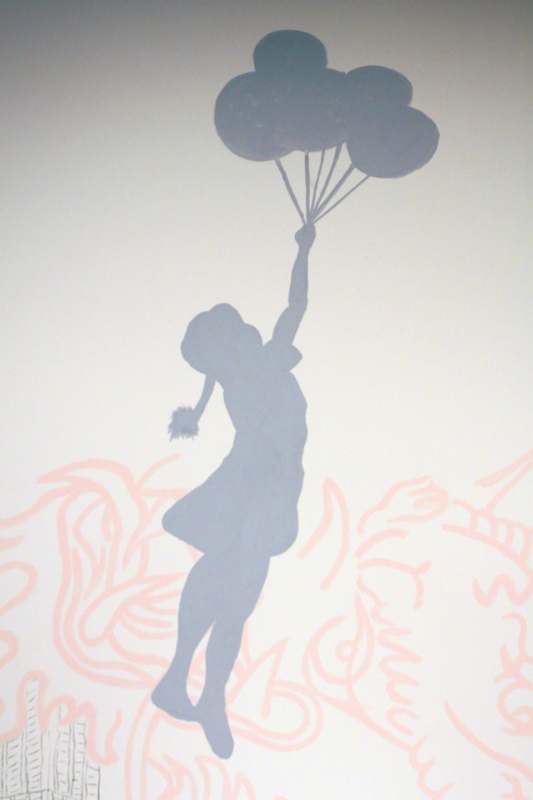 a shadow of a girl holding balloons