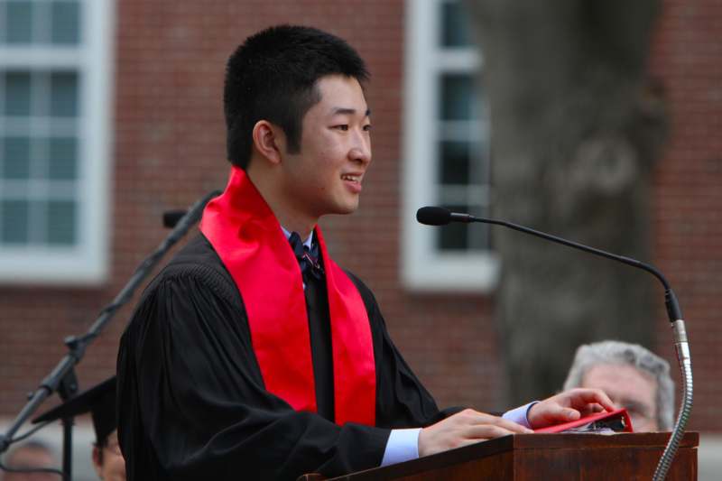 a man wearing a graduation gown and a red scarf
