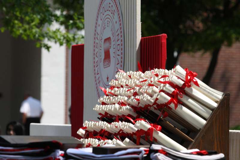 a stack of diplomas with red ribbons
