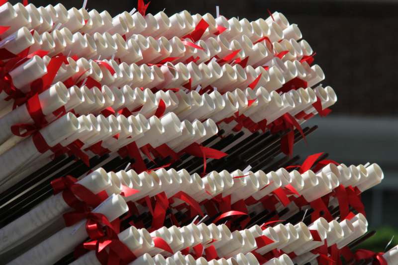 a stack of white paper scrolls with red ribbons