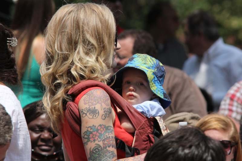 a woman carrying a baby in a carrier