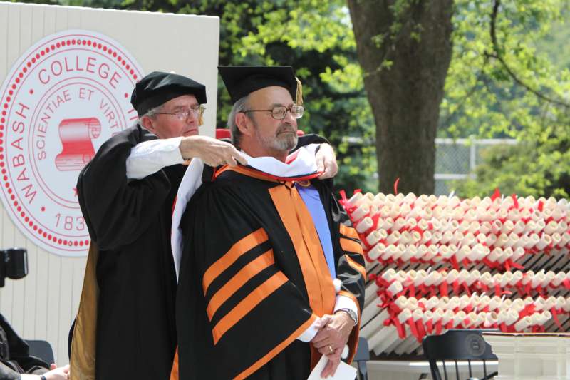 a man putting on a graduation gown