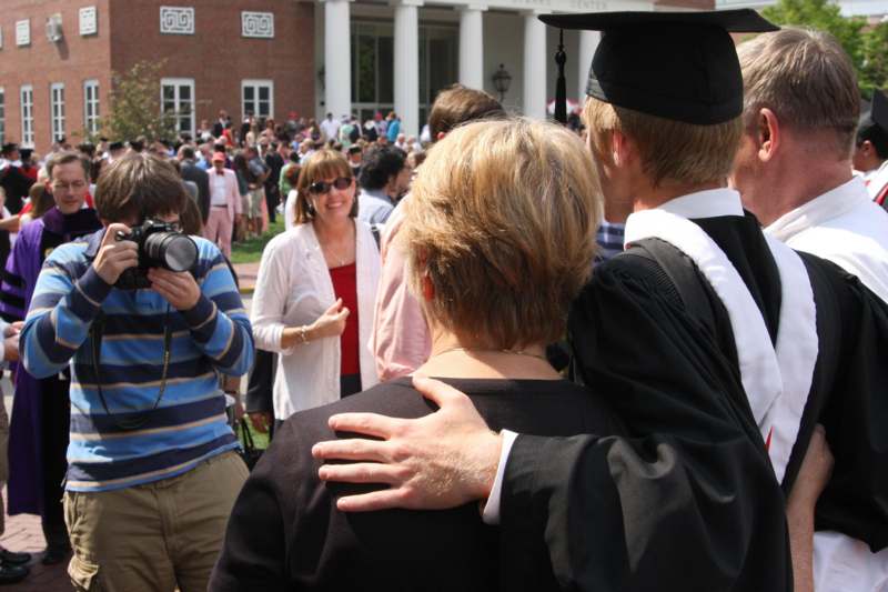 a man hugging a woman in a graduation cap