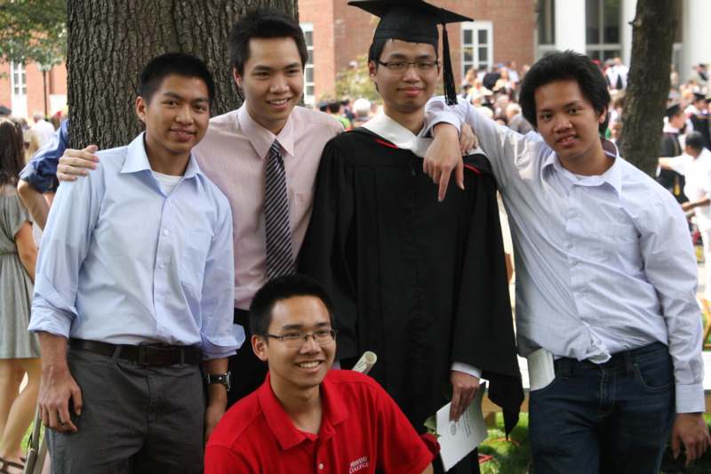 a group of young men in graduation gowns and cap and gown standing together