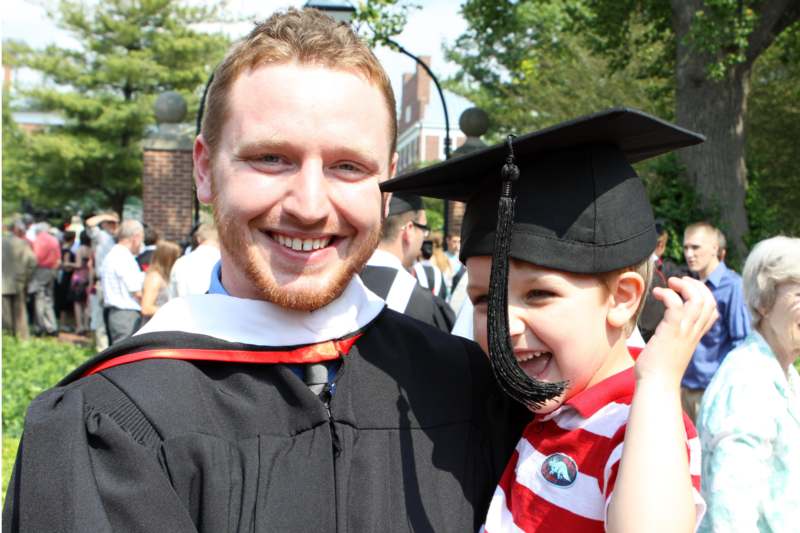 a man and child in graduation gowns