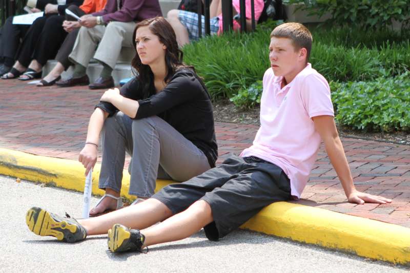a man and woman sitting on the curb