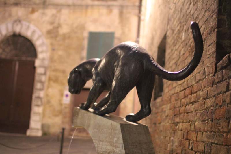a statue of a panther on a stone ledge