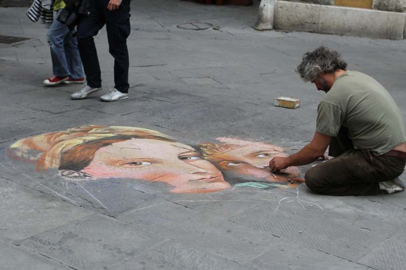 a man drawing on the ground