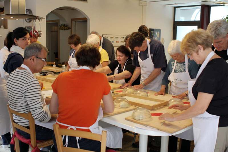 a group of people in aprons working on a table