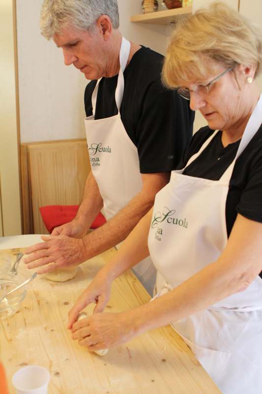 a man and woman in aprons making food