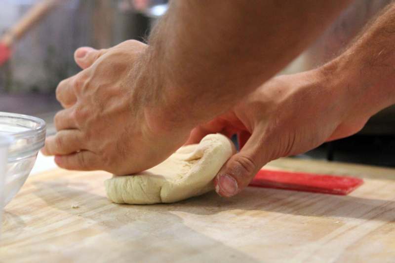 a person's hands making dough