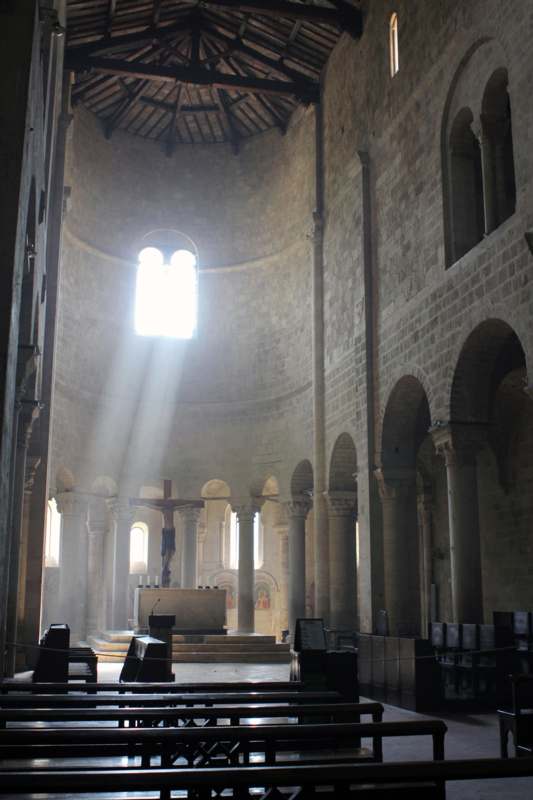 a light shining through the windows of a stone building