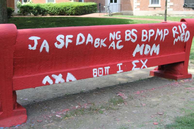 a red metal bench with white writing on it