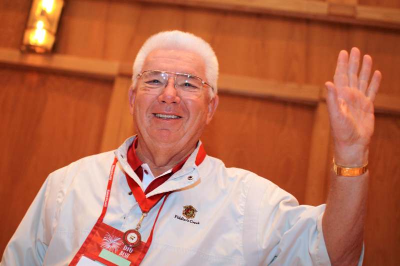 a man wearing a lanyard and holding his hand up