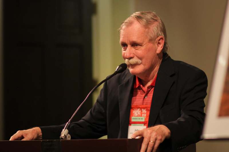 a man with a mustache speaking into a microphone
