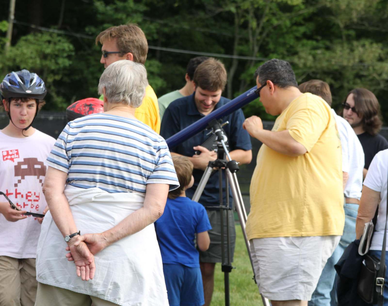 a group of people looking through a telescope