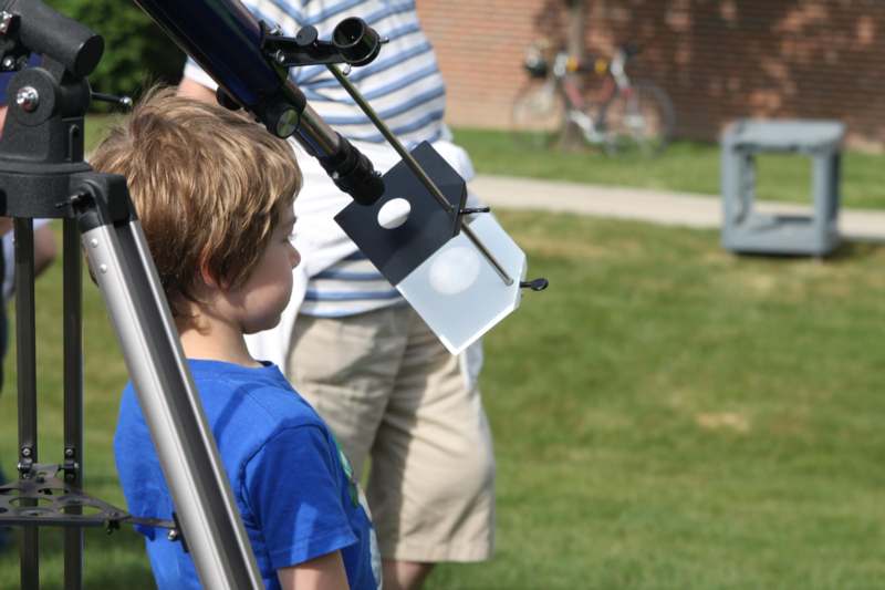 a child looking through a telescope