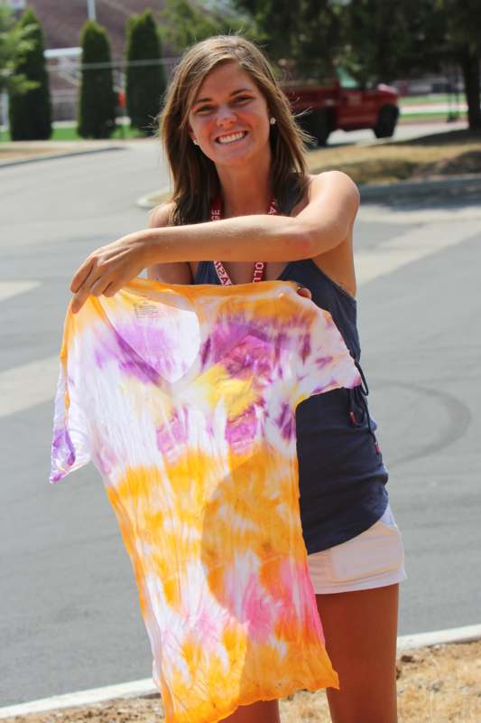 a woman holding a tie dye shirt