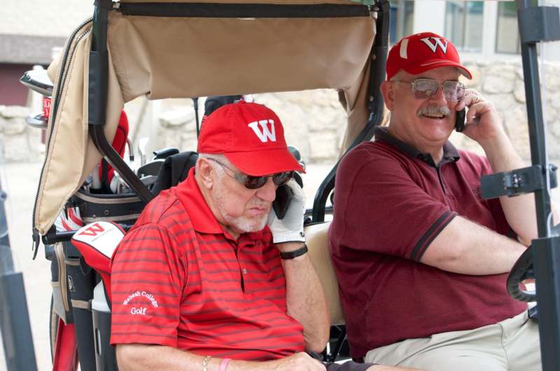 a pair of men in golf carts