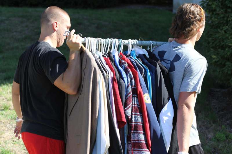 a man looking at a rack of clothes