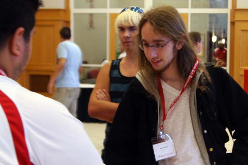 a man with long hair wearing a lanyard and a badge