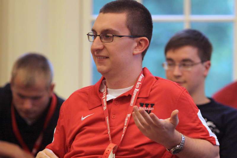 a man wearing a red shirt and a lanyard