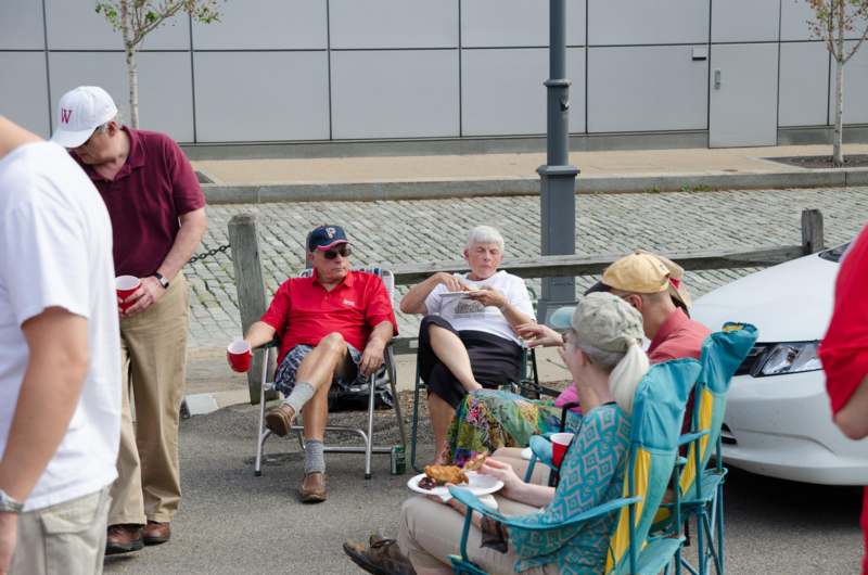 a man standing in front of a group of people sitting outside