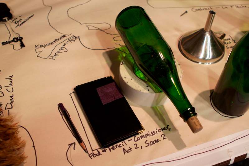 a green bottle on a piece of paper with a pen and a notebook